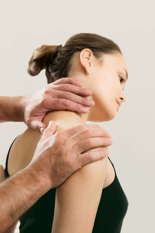doctor treating neck pain in patient
